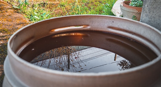 água armazenada em um barril de metal em uma área rural