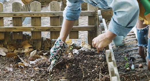 pessoa fazendo compostagem para usar em seu jardim sustentável