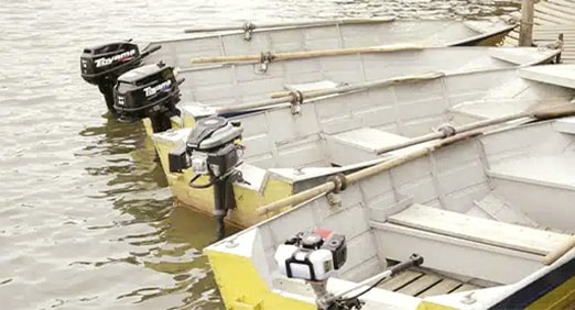 Barcos equipados com o motor de popa da Toyama ancorados no rio.